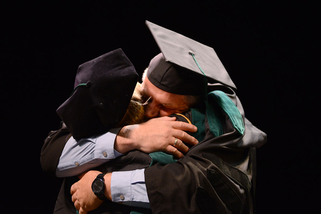 Natalie and Peter Kukulka embrace onstage during commencement